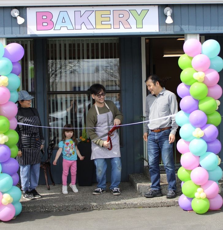 gene hainey cutting the ribbon to open the bakery